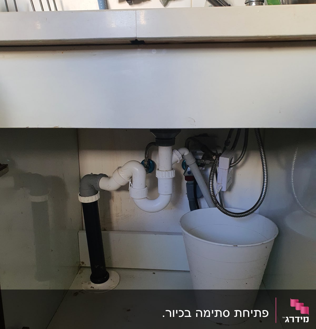 צנרת מתחת לכיור עם דלי לבן